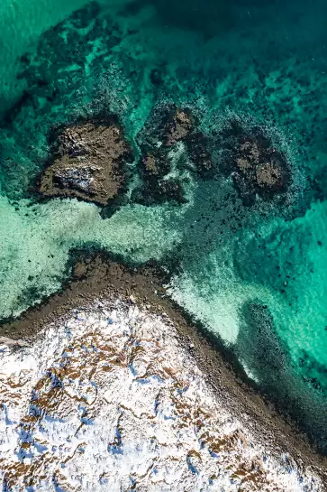 Roche enneigée et mer turquoise - paysage hiver