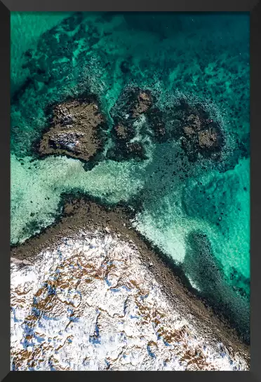 Roche enneigée et mer turquoise - paysage hiver